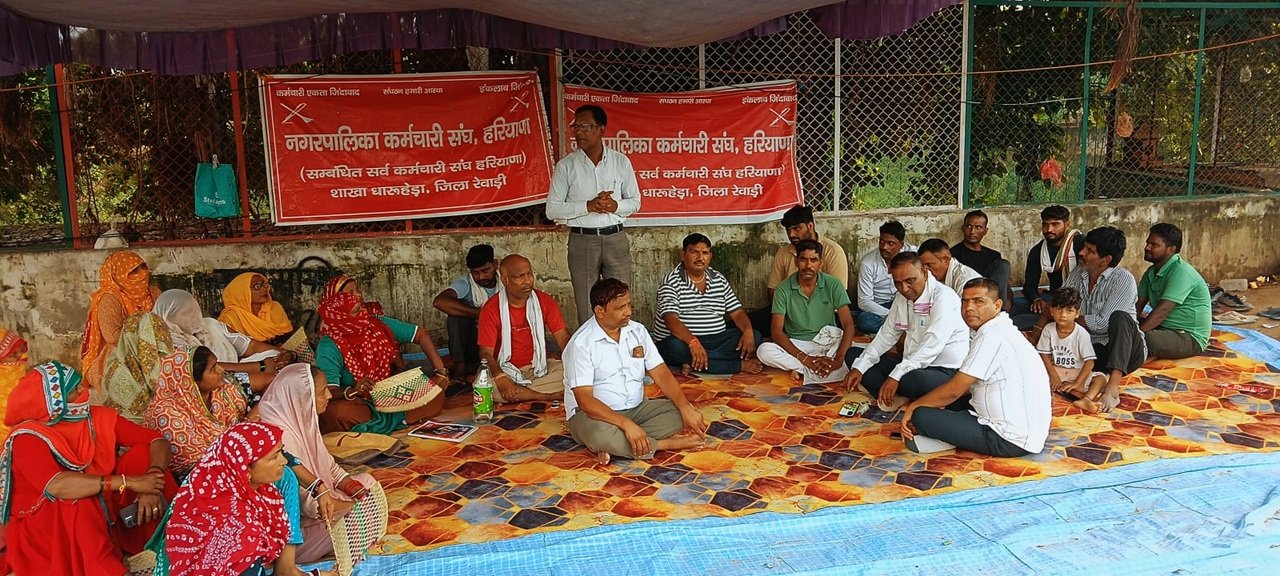 धारूहेड़ा: मांगो को लेकर धरने पर बैठे सफाई कर्मी विरोध प्रदर्शन करते हुए