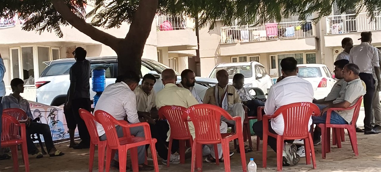 एम2के काउंटी हाइट्स आरडब्ल्यूए के चुनाव में वोटिंग सेंटर के बाहर बैठे लोग